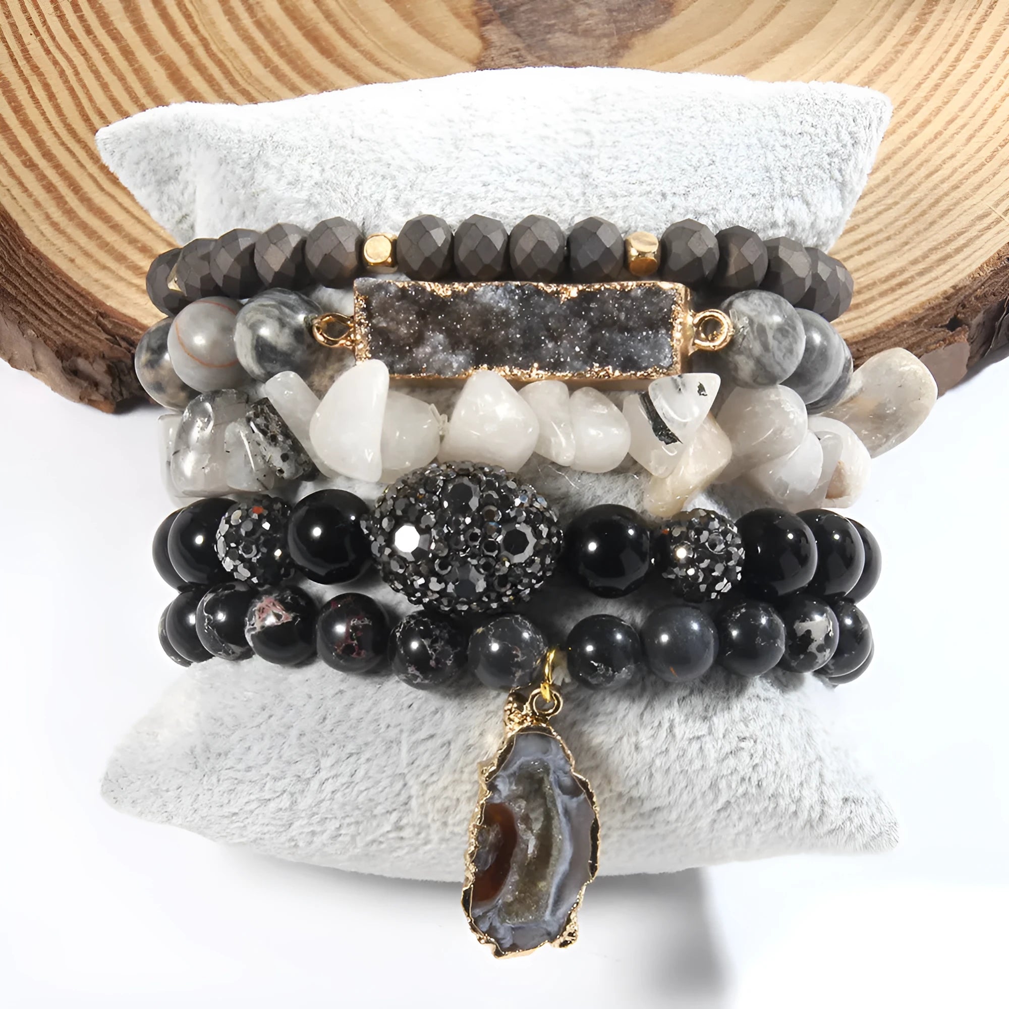 Set of five handmade stretch bracelets with glass, crystal, and hematite beads in irregular shapes on a neutral background