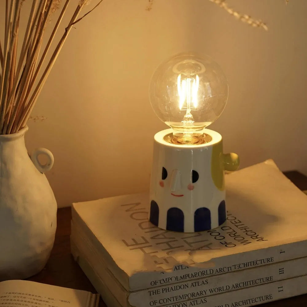 Handmade ceramic table lamp with ball headlight shade on wooden surface