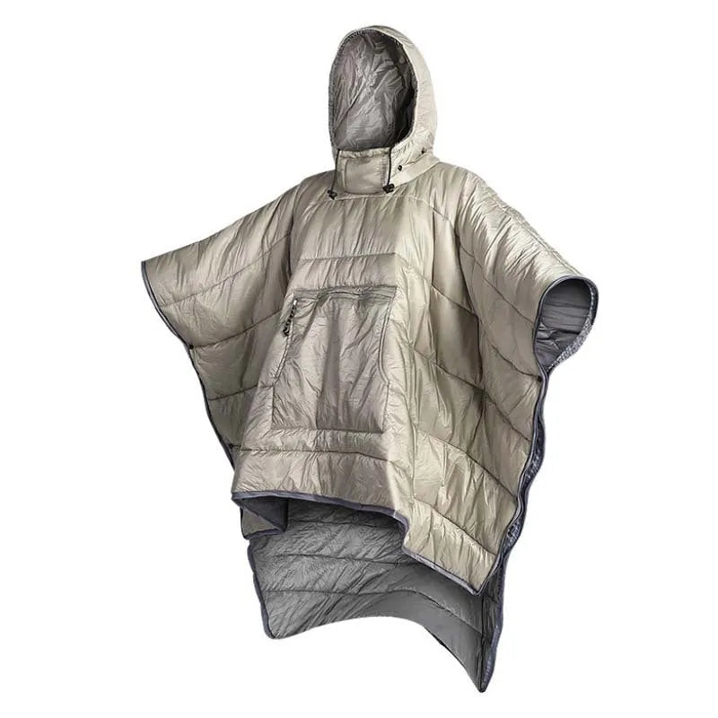 Adult wearing grey nylon cloak sleeping bag as wearable camping blanket outdoors