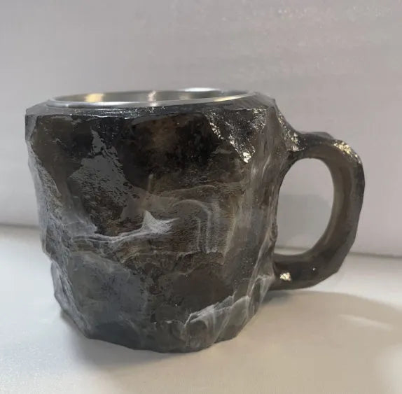 Purple and blue resin coffee mug with crystal texture and handle on wooden table