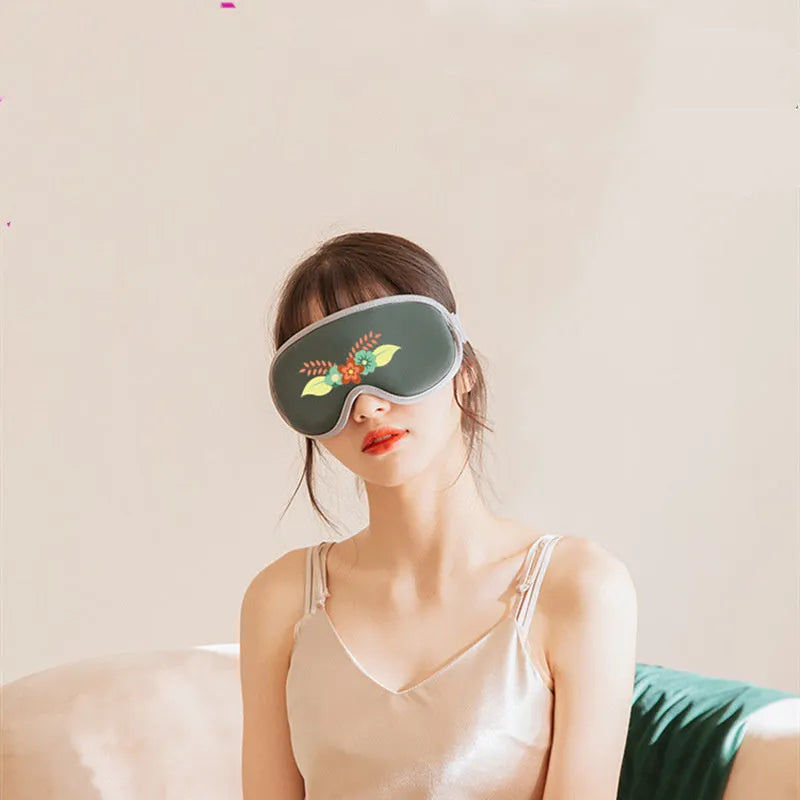 Pink and green portable eye SPA mask with USB cable, showing suede exterior and super fibre interior.