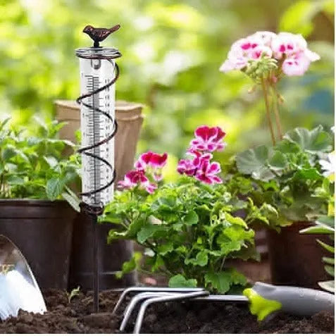Cast iron garden rain gauge with hummingbird ornament and measurement scale.