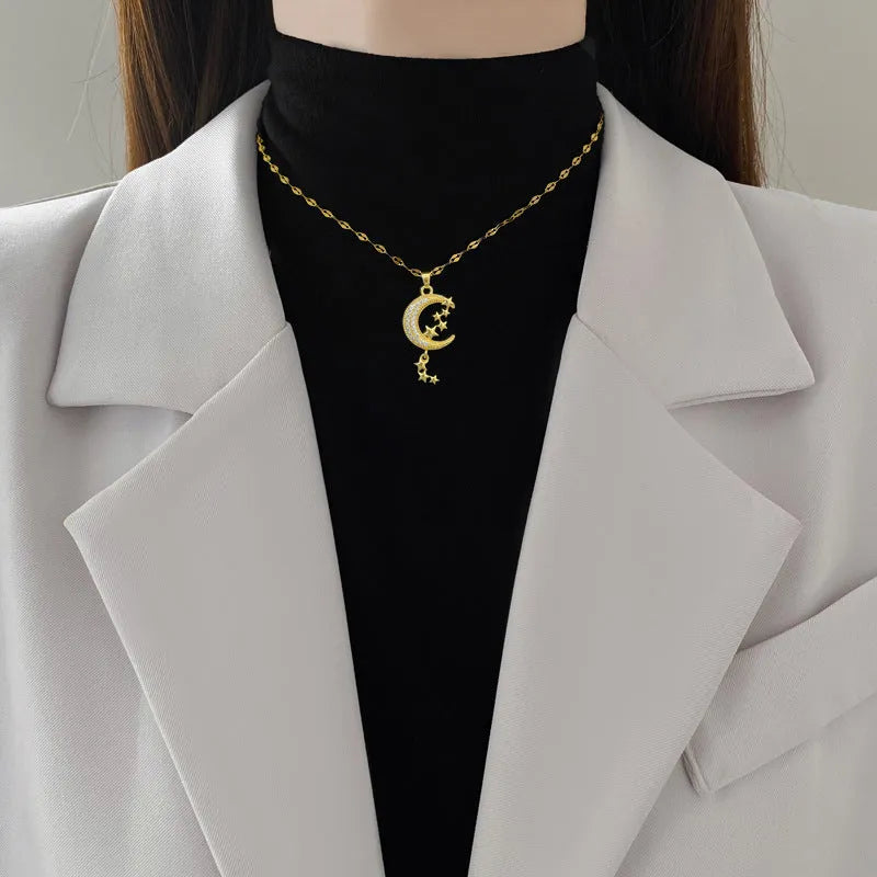 Moon pendant necklace with diamond accents and tassel on stainless steel chain