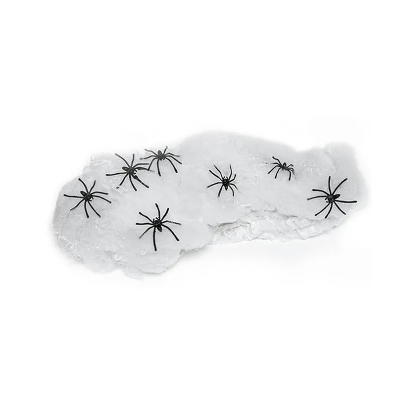White cotton spider web Halloween decoration with integrated synthetic spiders draped over fence