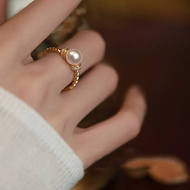 Adjustable antique-style copper ring with twisted geometric band and a pearl inlay centre.