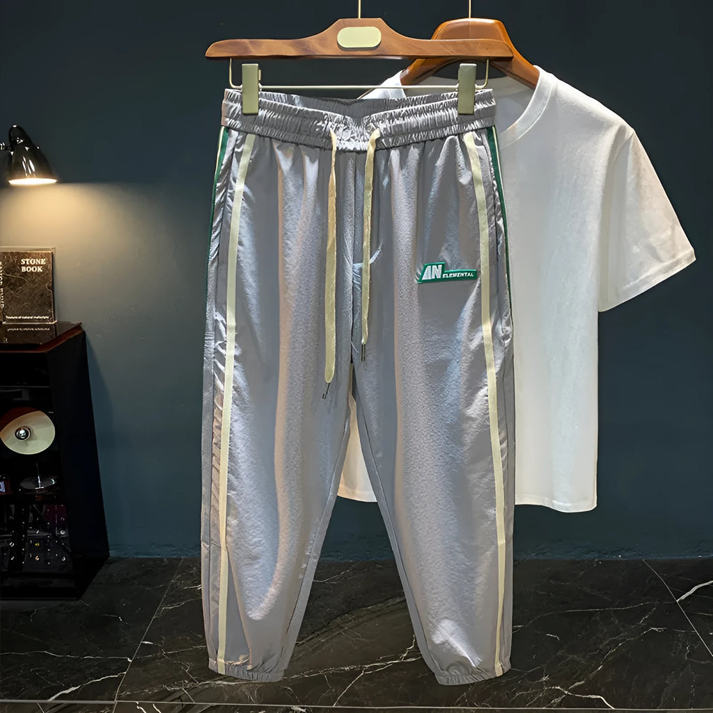 Men's black cotton harem pants with a mid-waist and solid colour design laid flat.