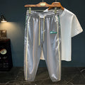 Men's black cotton harem pants with a mid-waist and solid colour design laid flat.