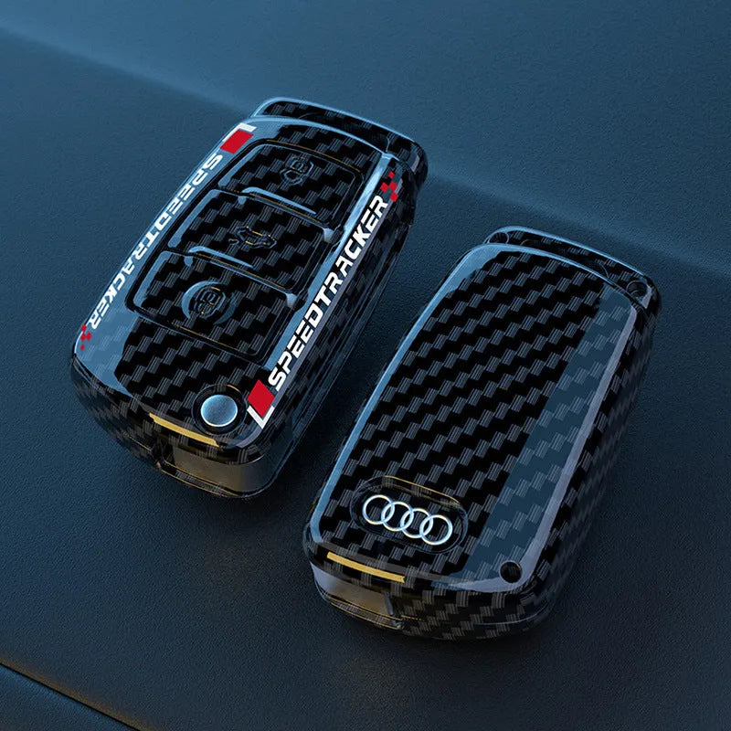 Carbon fibre pattern car key cover with a small rectangular mirror set into the feilin material casing.