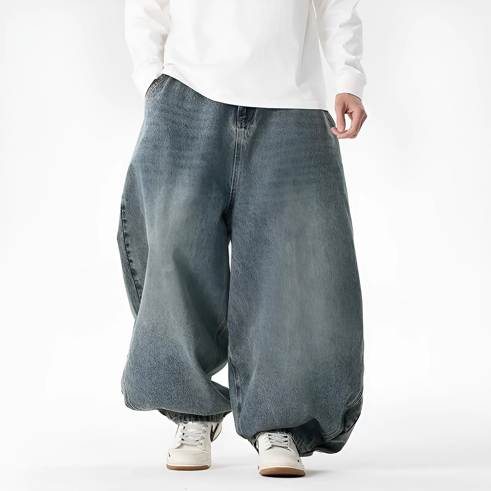 Men's plus-size baggy blue jeans with a wide leg and straight hem on a casual background.