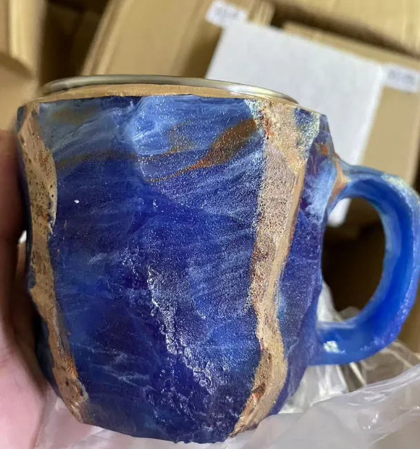 Purple and blue resin coffee mug with crystal texture and handle on wooden table