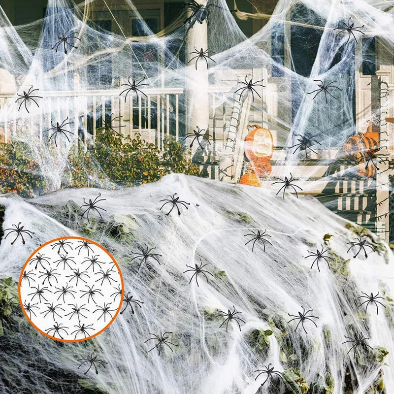 White cotton spider web Halloween decoration with integrated synthetic spiders draped over fence