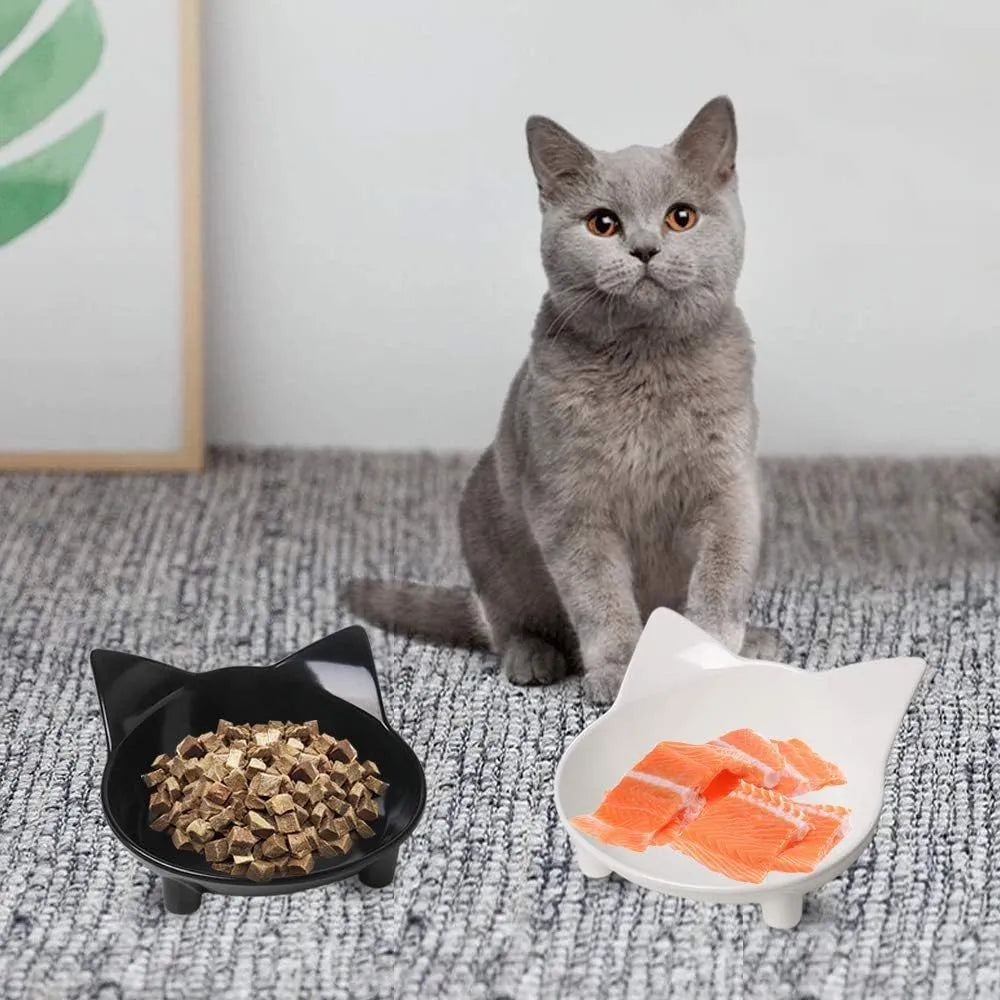 Set of four black shallow melamine pet bowls with non-slip rubber bases on a white surface.