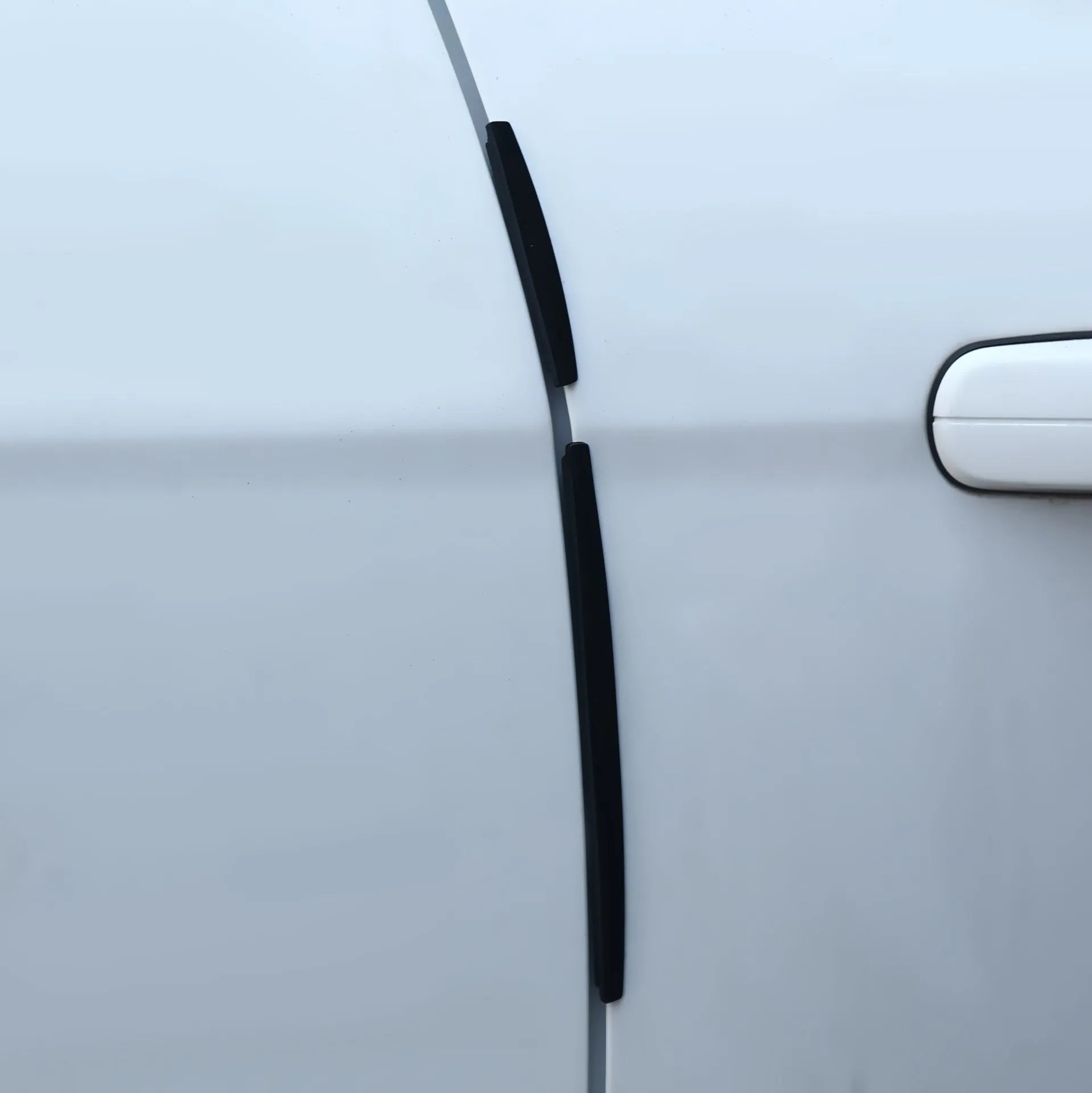 White plastic car door edge protector strip on a vehicle door.