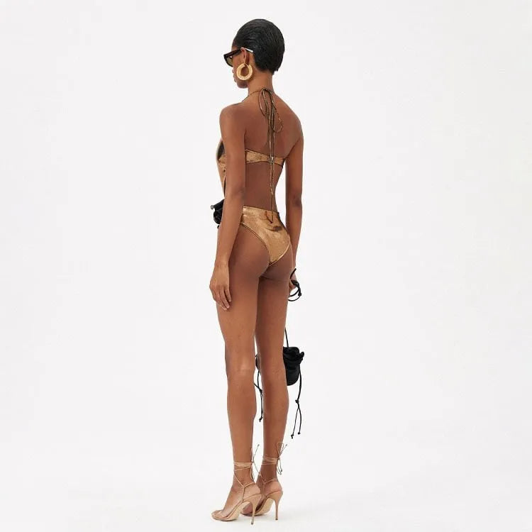 Gold women's halter neck one-piece swimsuit with hollow-out design on mannequin