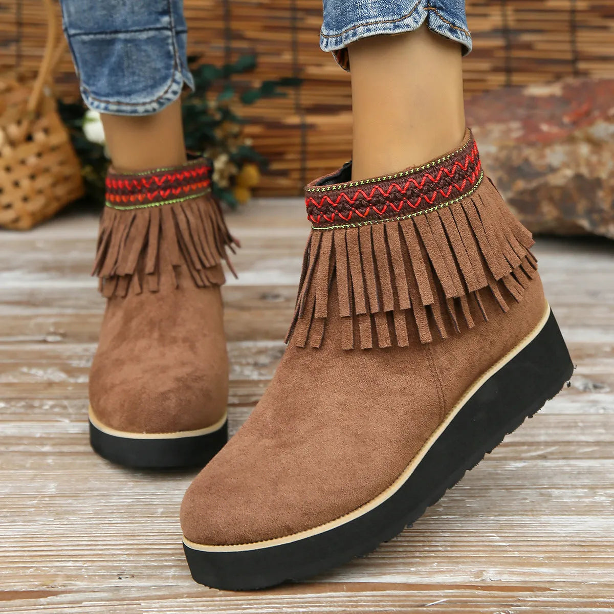 Women's suede ankle boot with wedge rubber sole, side zip, and tassel detail in dark brown.