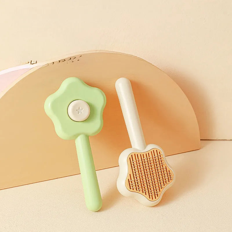 Green and yellow self-cleaning cat comb with stainless steel needles for pet grooming.