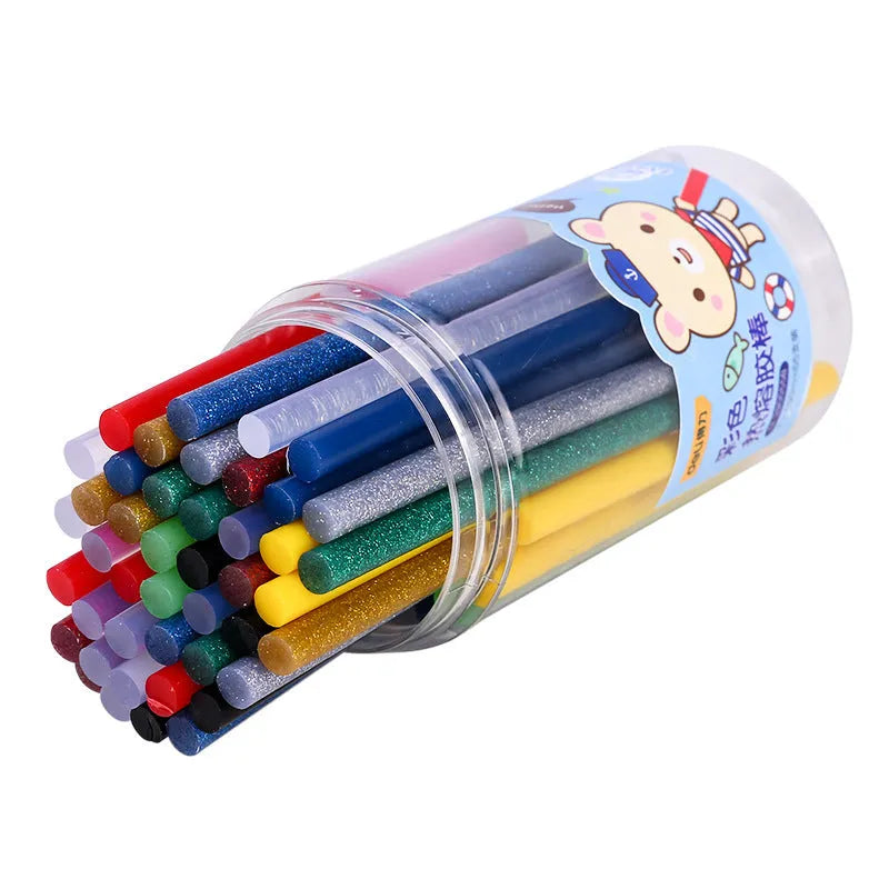 Pack of 55 clear hot melt glue sticks with 7mm diameter next to a glue gun