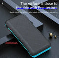 Black portable solar power bank with wireless charging pad and three USB ports on a wooden surface.
