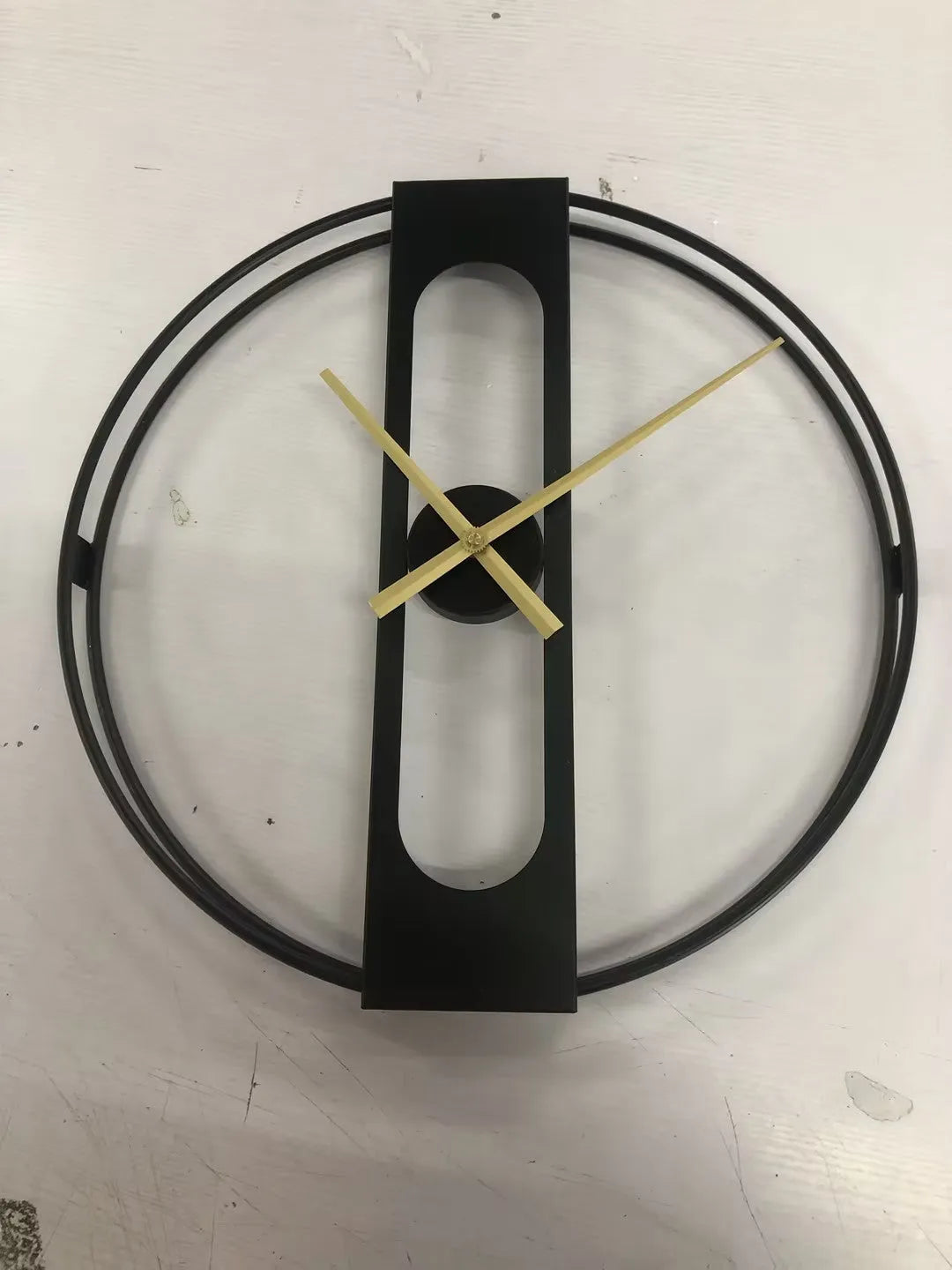 Round metal wall clock in black or gold, 50 cm diameter, on a white wall.