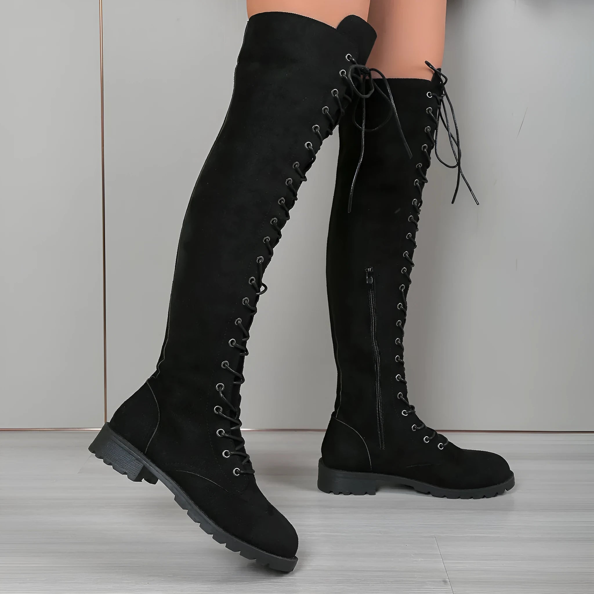 Black lace-up over the knee flat heel boots with stitching details on a round toe.