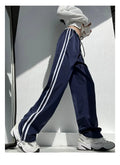 Navy blue loose straight leg drape pants with a low waist and thin fabric, laid flat.