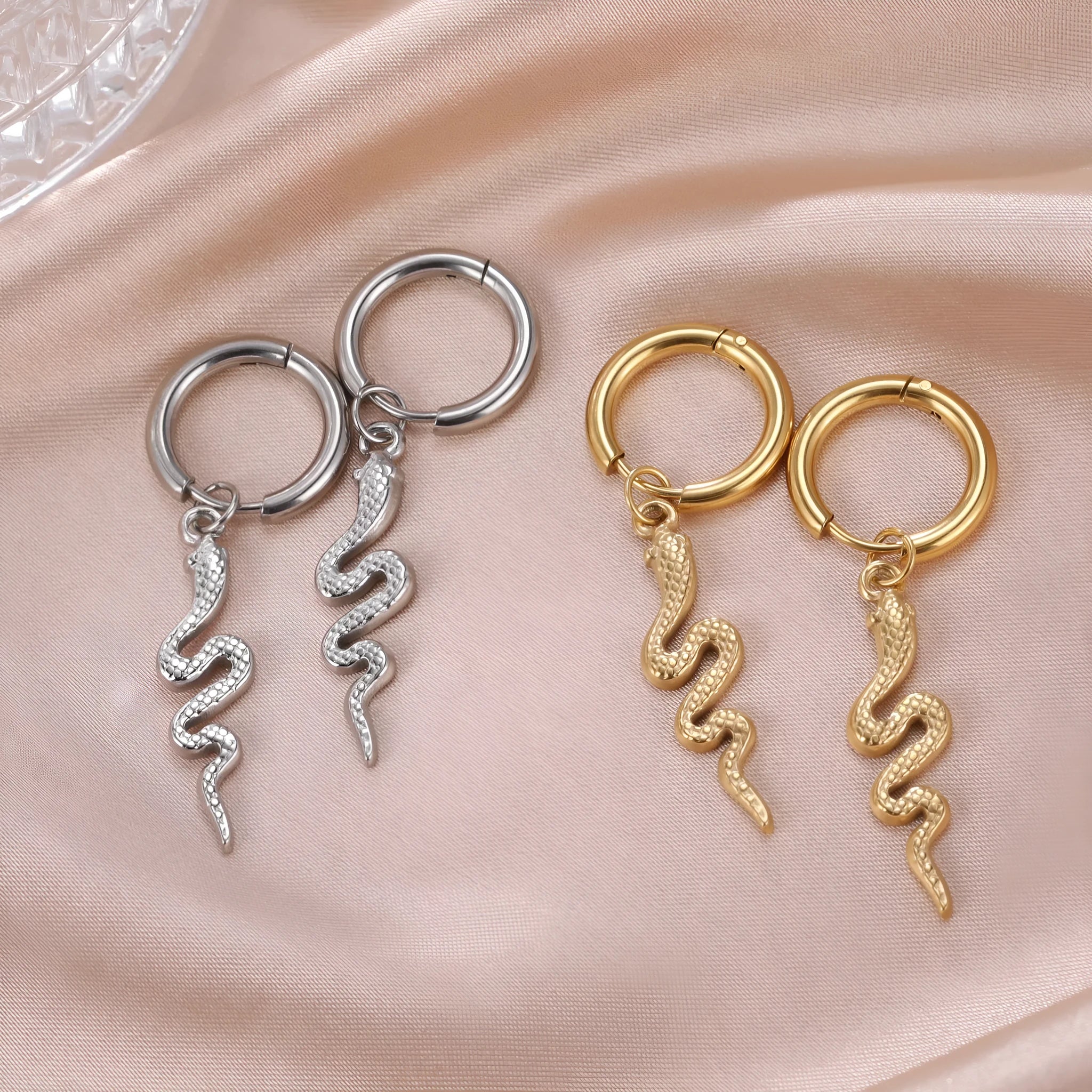 A pair of vintage-style snake-shaped earrings made from gold plated stainless steel with an ear clip fastening.