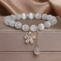 Women's white cat's eye crystal bracelet with flower tassel charm and safety buckle pendant clasp