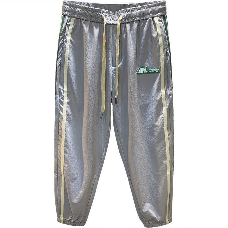 Men's black cotton harem pants with a mid-waist and solid colour design laid flat.