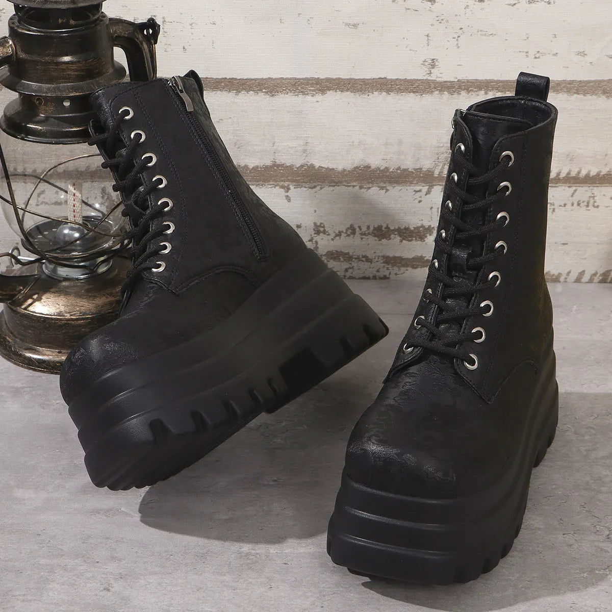 Women's black platform Martin boots with chunky heel and side zipper on a white background.