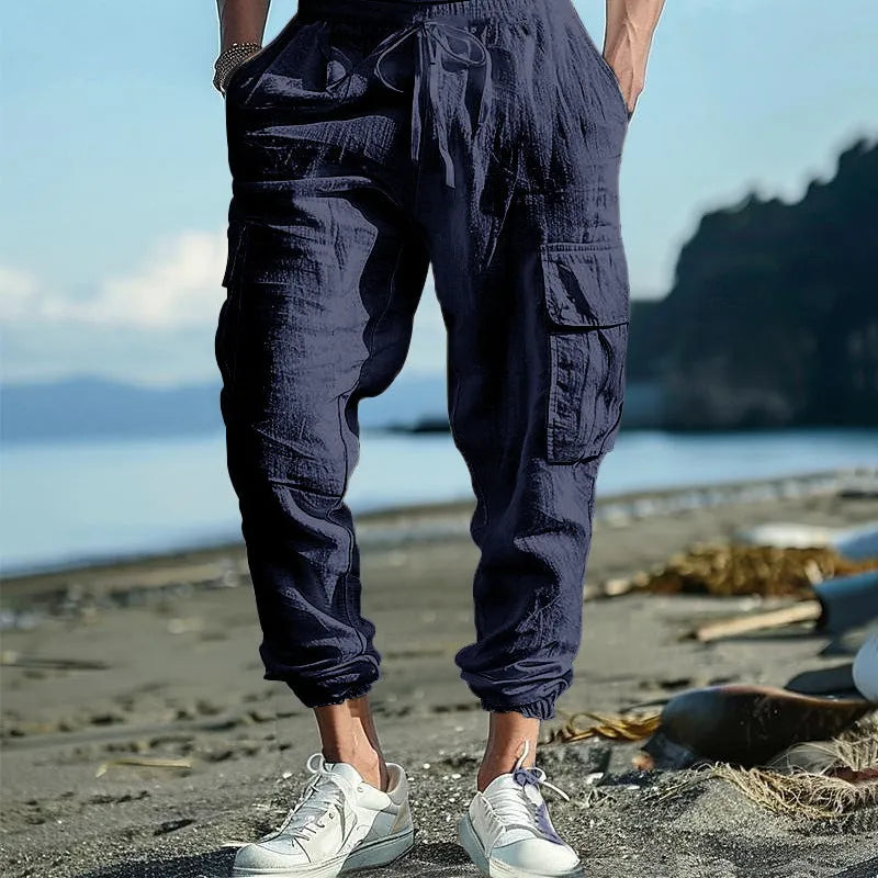 Men's loose-fit linen casual trousers with ankle-tied cuffs and multiple pockets in a solid colour.