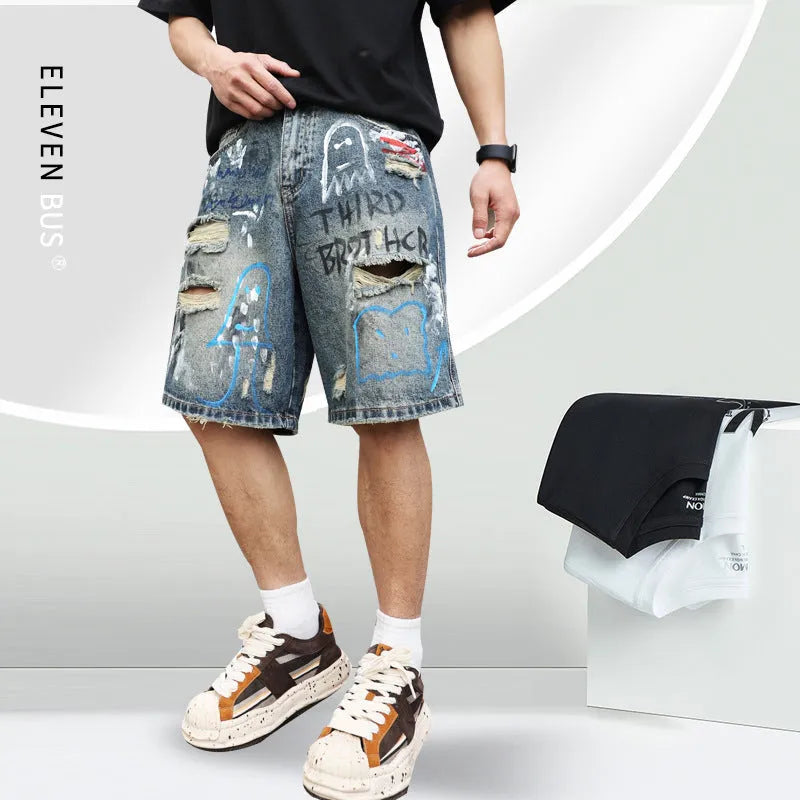 Blue men's denim shorts with ripped knees and graffiti图案, featuring a straight leg and zipper fly.