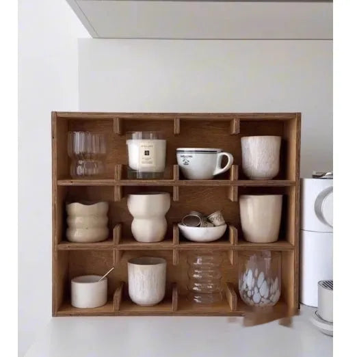 Solid square wood storage rack with multiple grid compartments for cups and mugs in birch wood colour.