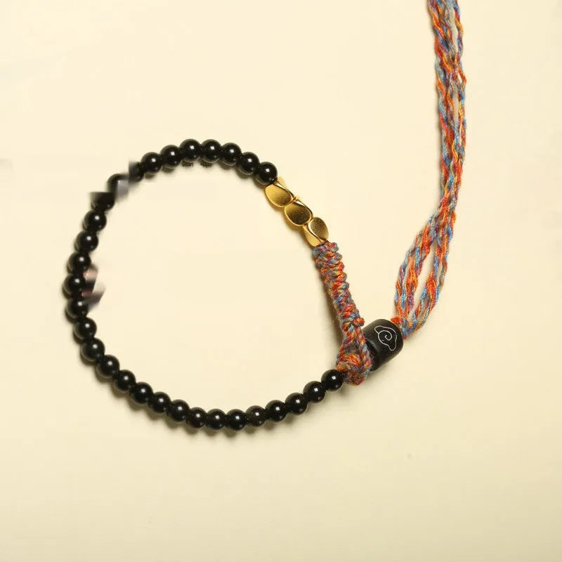 Hand-woven obsidian bracelet with dark beads showing woven texture and adjustable 15.5-16cm length