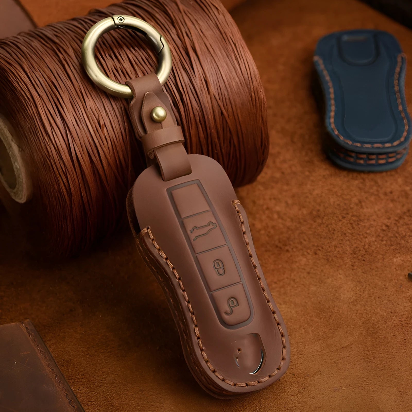 Brown leather Porsche key case with a metal buckle closure.