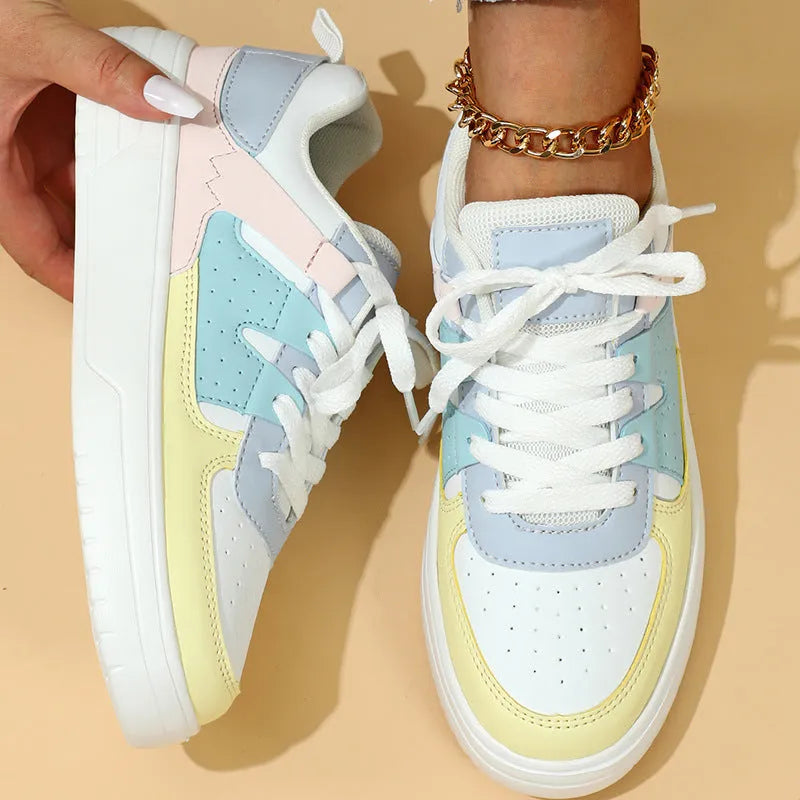 Trendy platform sneakers with white and yellow moon colour block, cross straps, and lace-up closure on a light background