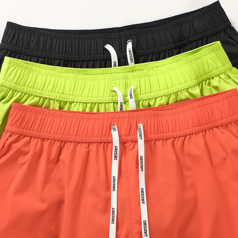 Men's loose orange, fluorescent green, or black polyester beach shorts on a size chart