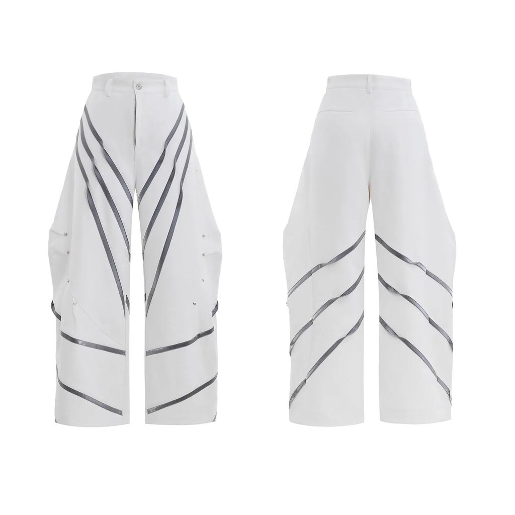 Men's black trousers with three-dimensional cutting and metal rivet pleats on a white background.