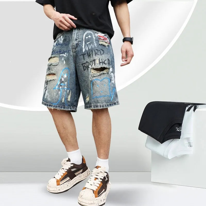 Blue men's denim shorts with ripped knees and graffiti图案, featuring a straight leg and zipper fly.