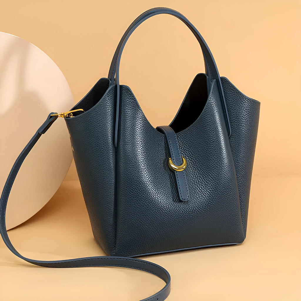 Genuine leather women's hand holding bucket bag in retro style with file compartment interior.