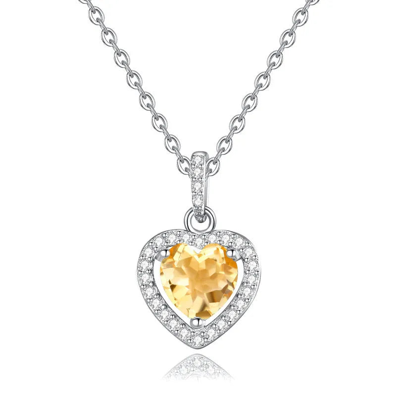 Women's sterling silver heart necklace with a round amethyst gemstone pendant on a cross chain.