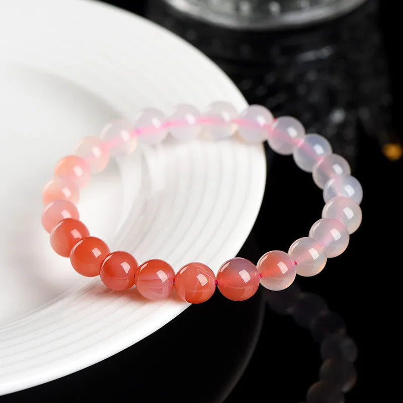 Natural gradient Yanyuan agate bracelet with smooth geometric beads on a wrist.