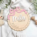 Customisable square wooden baby room ornament with a name, shown in two size options.