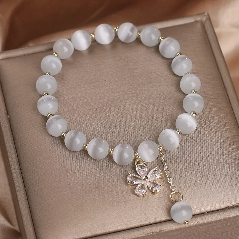 Women's white cat's eye crystal bracelet with flower tassel charm and safety buckle pendant clasp