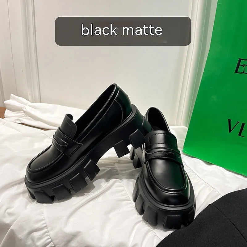 A pair of British style wide fit loafers with a muffin heel, shown in patent leather and matte colour options.
