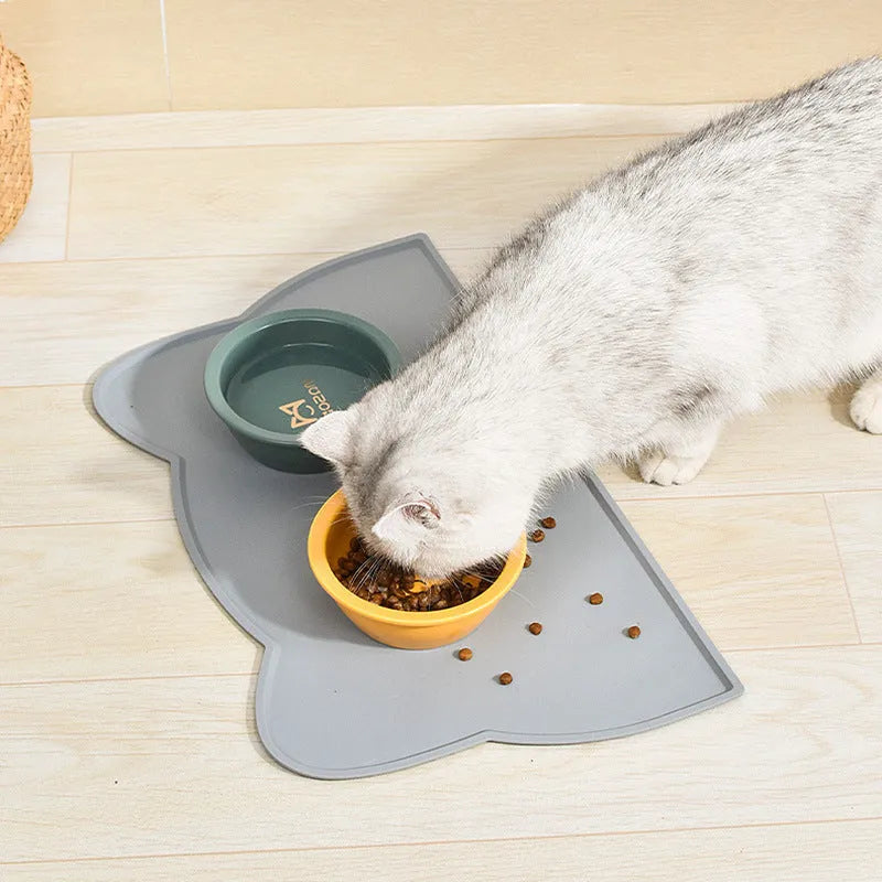 Blue waterproof silicone pet feeding mat for dog or cat bowls on a wooden floor.