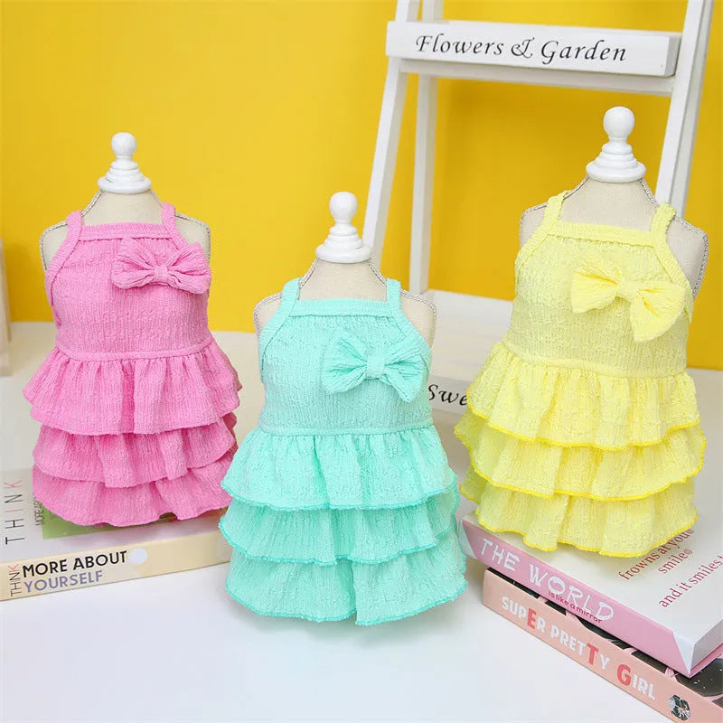 Small dog wearing princess dress with candy layered skirt in rose red, yellow, or water green