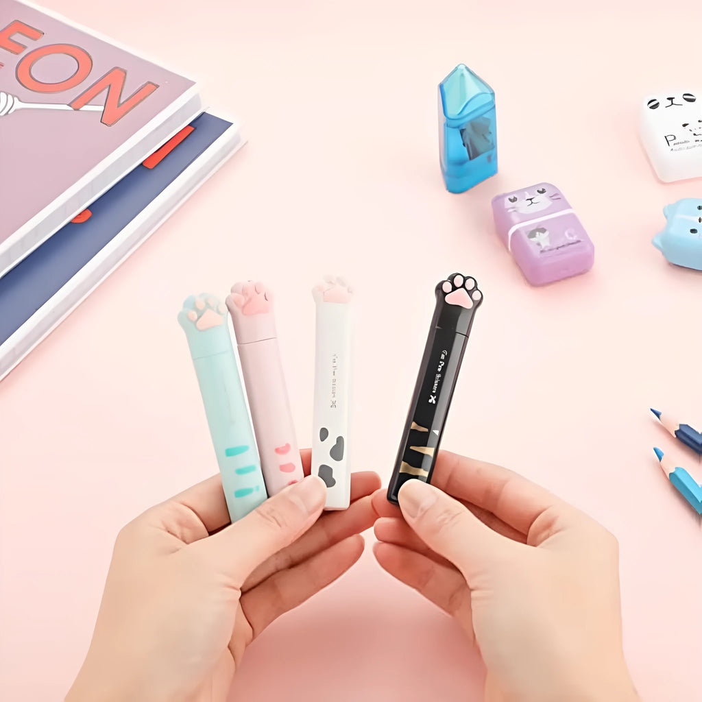 Set of four small folding scissors with cat paw handles in black, blue, pink, and white colours.