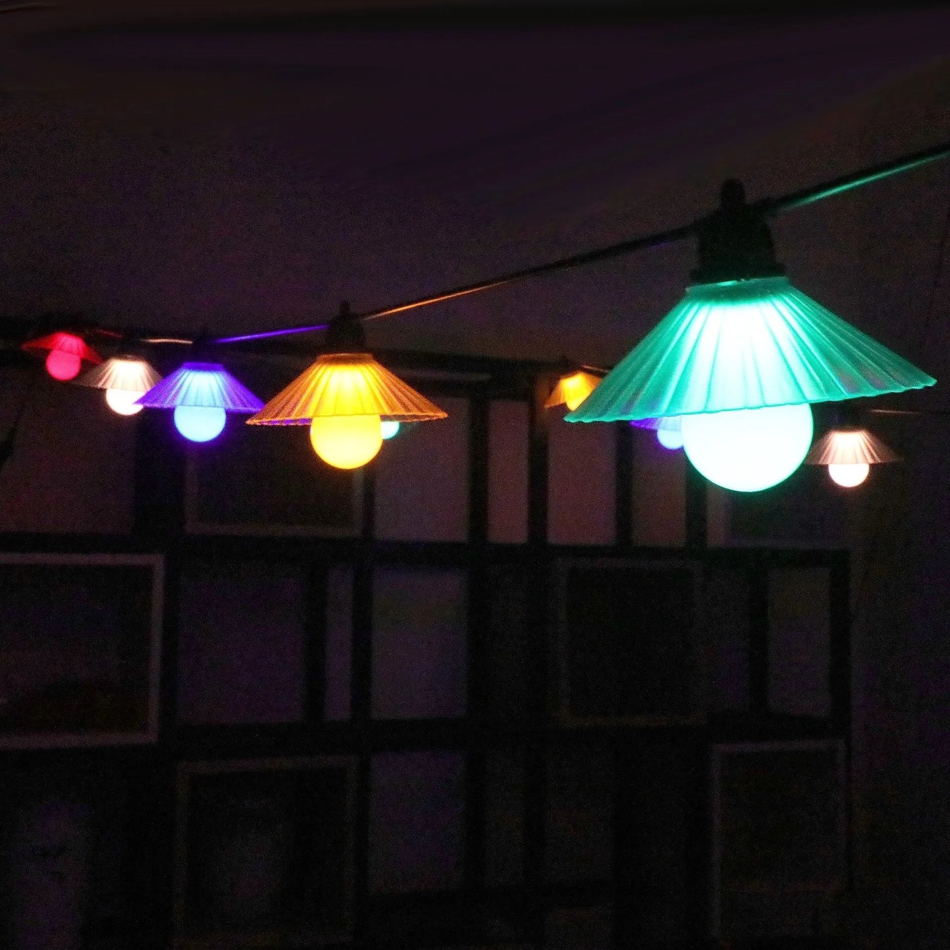 Outdoor LED string lights with flower-shaped coloured globes for garden patio decoration