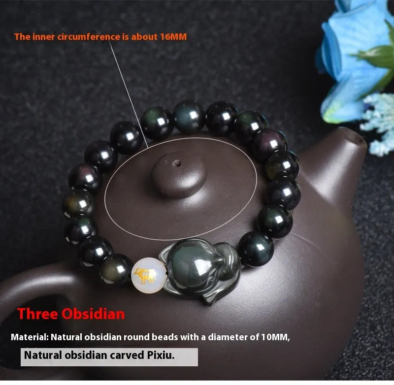 Natural black obsidian bracelet with 10mm beads on wrist, showing gold tone fastening option.