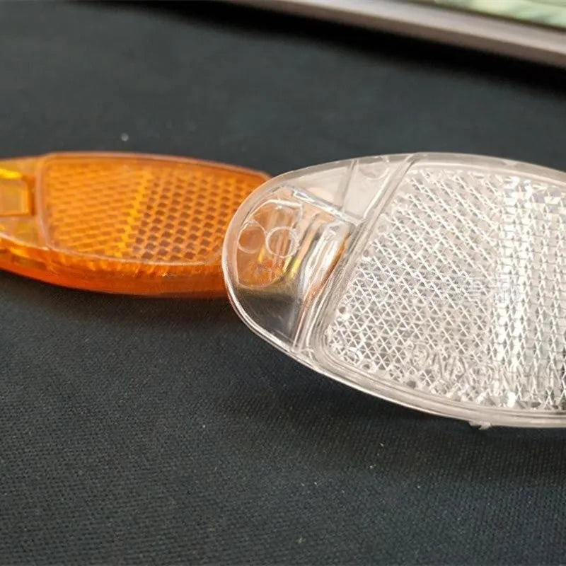 White and yellow plastic bicycle spoke reflectors with reflective warning film